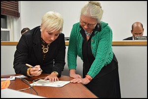 Over two years ago City Manager Katrina Powell (left) started off her job here by signing her employment contract with Mayor Karen Majewski. Now it appears a bare majority of councilmembers are against extending her contract, which expires on June 30.